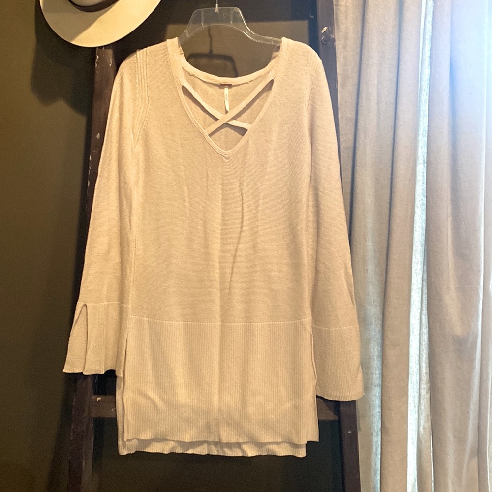 Cream Free People sweater has crisscrossed cutout in front. Size small